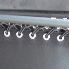 Garden lounger with plastic grommets